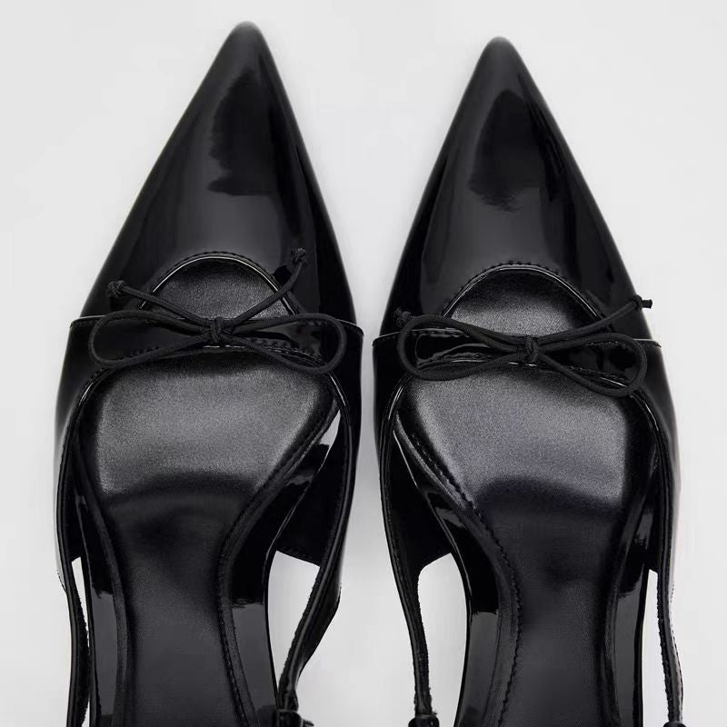 Black patent leather bow with pointed tip thin heel and a shallow strap for women's sandals